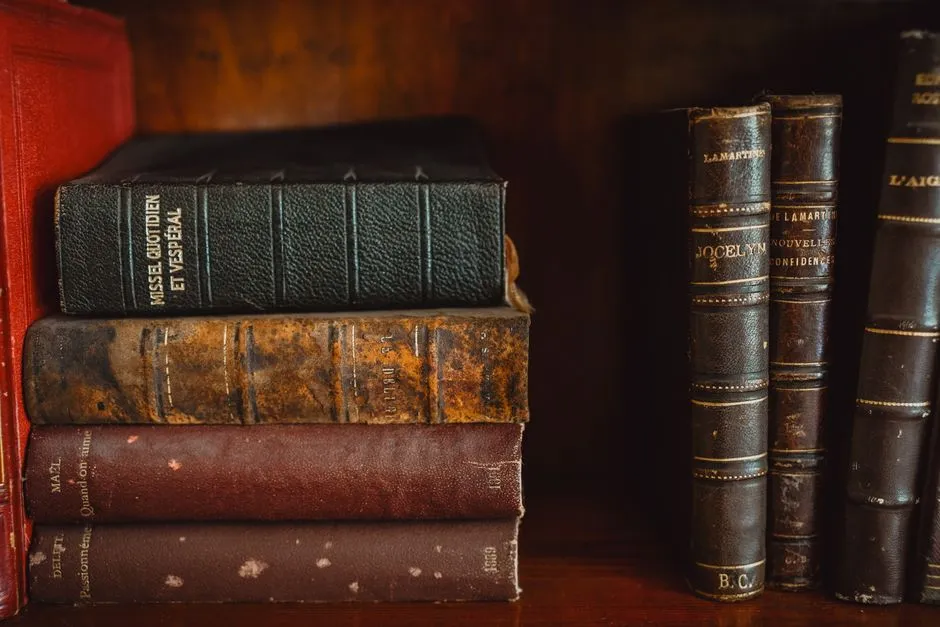 Bound newspaper volumes on a library shelf, spines stamped with years in faded gold lettering