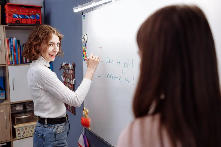 Teacher writing a date on a whiteboard in front of a class