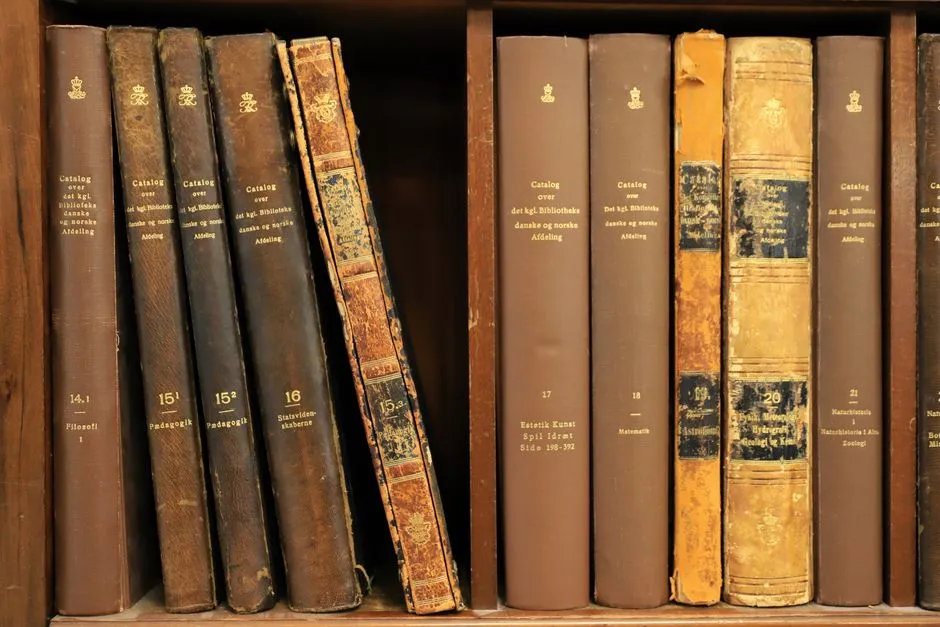 Bound newspaper volumes open on a library reading table